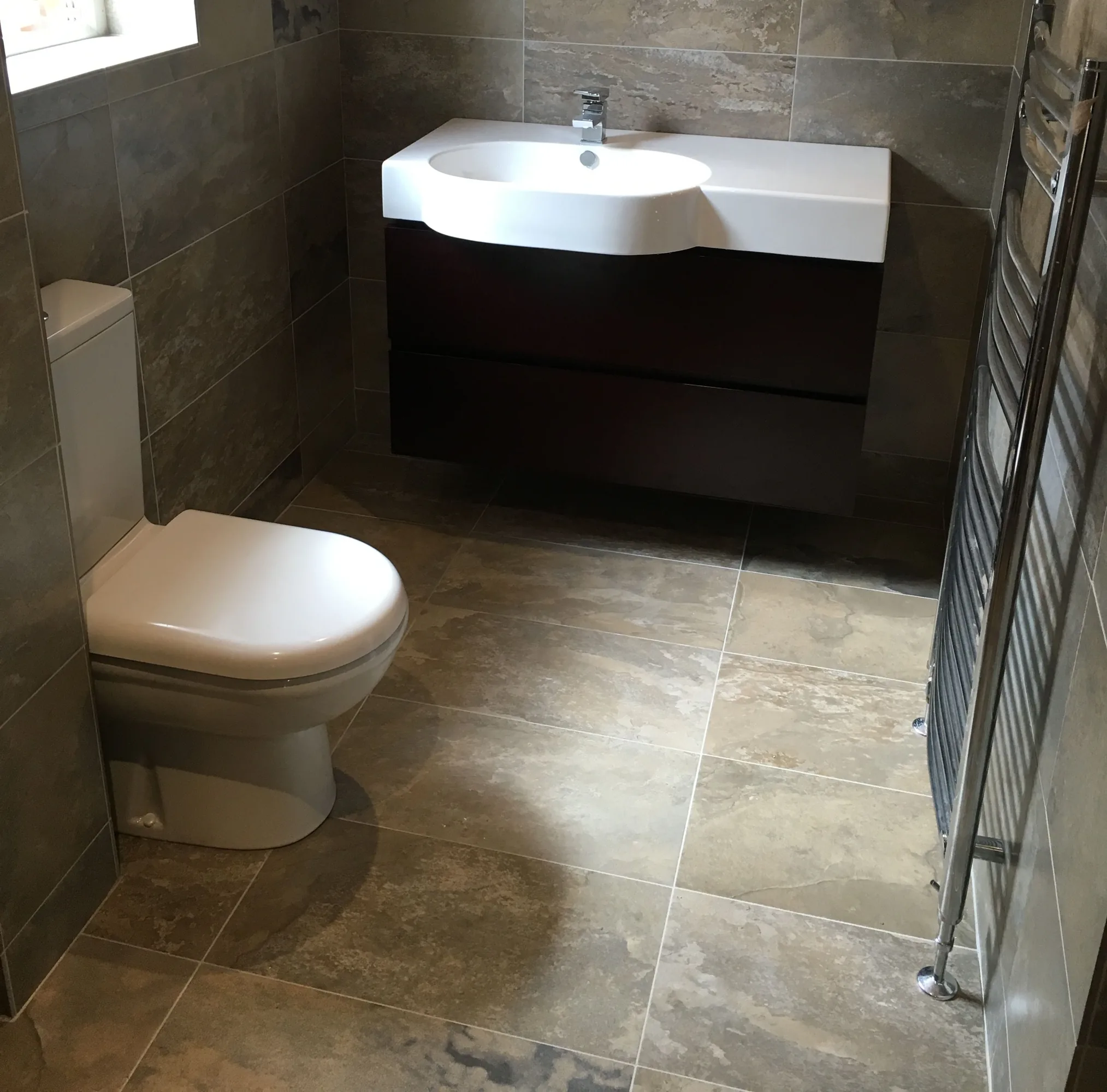 New bathroom with vanity unit, basin and stone-effect tiling by PARAGAS